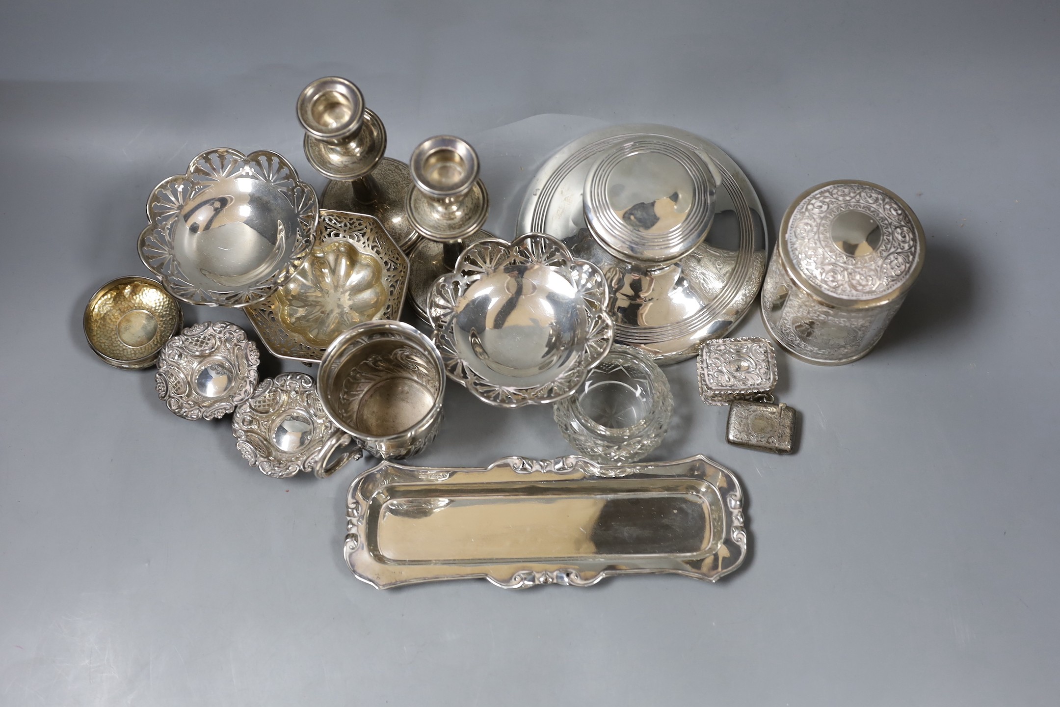 Assorted silver including a capstan inkwell, pair of dwarf candlesticks, pair of pedestal nut dishes, one other dish, christening mug, pin tray, five other items and an Indian white metal canister and cover.